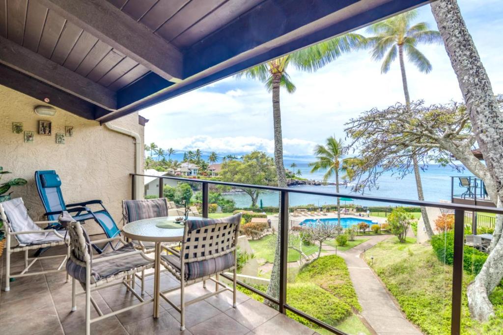 a patio with a table and chairs and a view of the ocean at K B M Resorts- NAP-C37 Gorgeous 2Bed2Bath ocean view, easy access to parking, pool and beach in Kapalua