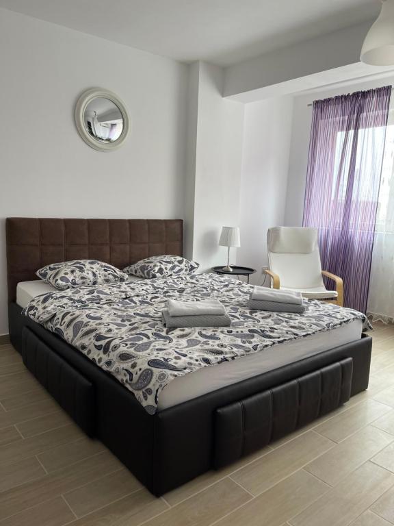 a bedroom with a bed with two controllers on it at Zeini - Garsoniera Constanta in Constanţa