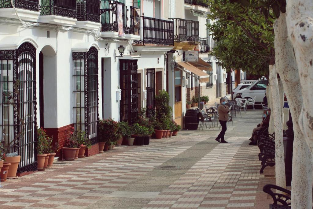 Una mujer caminando por una calle en una ciudad en Casa Pepe La Rosa Atico en Tolox