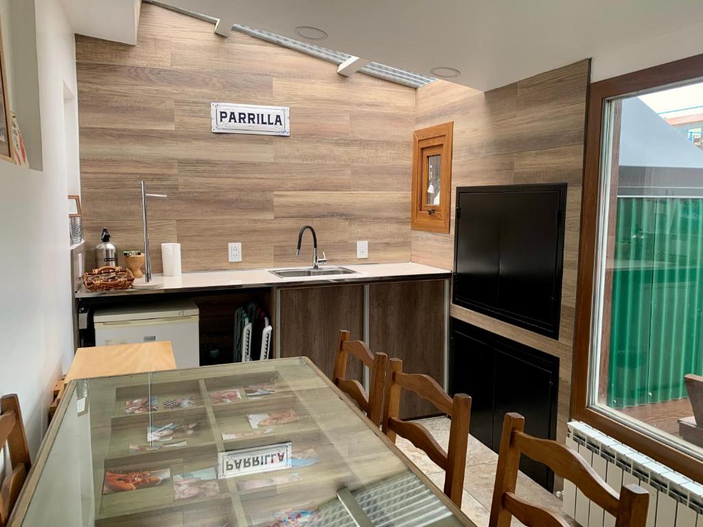 a kitchen with a glass table with chairs and a sink at Increible Casa ideal Familias in Ushuaia