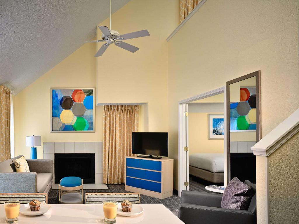 ein Wohnzimmer mit einem Sofa und einem TV in der Unterkunft Sonesta ES Suites Tucson in Tucson