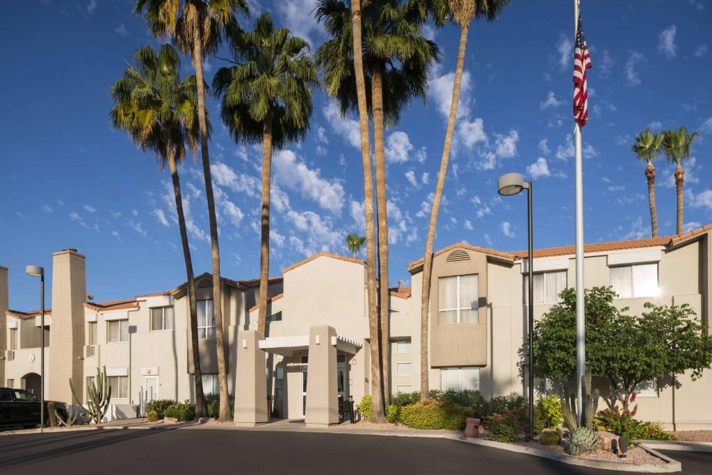 uma fila de palmeiras em frente a um edifício em Sonesta ES Suites Scottsdale Paradise Valley em Scottsdale