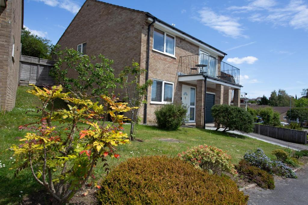 a brick house with a garden in front of it at Henbury Hide in Corfe Mullen