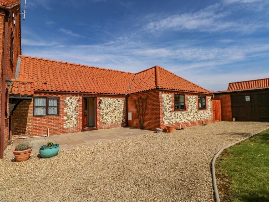 a brick house with an orange roof at The Granary Cottage in Gayton