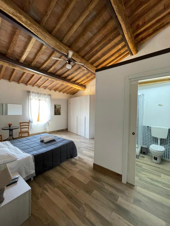 una grande camera da letto con letto e soffitto in legno di Il Feudo a Certaldo