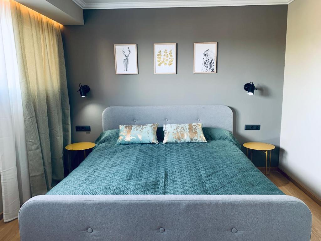 um quarto com uma cama com um edredão verde e 2 mesas em Top Ferienwohnung ALBERGO in Altenau em Altenau