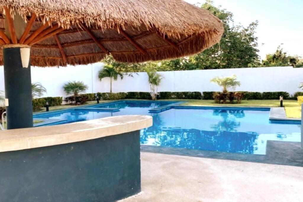 una piscina con sombrilla de paja y un complejo en Casa en Cancún en Cancún