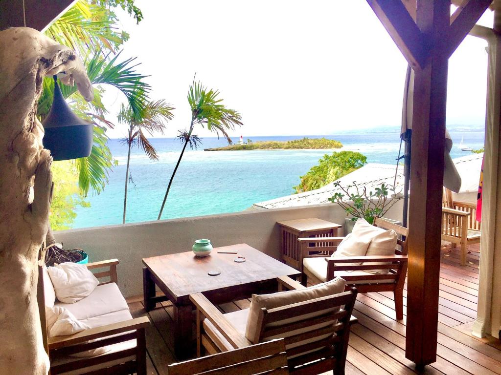 a balcony with a table and chairs and a view of the ocean at Kazasoley in Le Gosier
