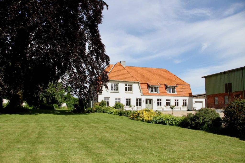 a large white house with an orange roof at B&B Angeliter Landidyll in Gelting