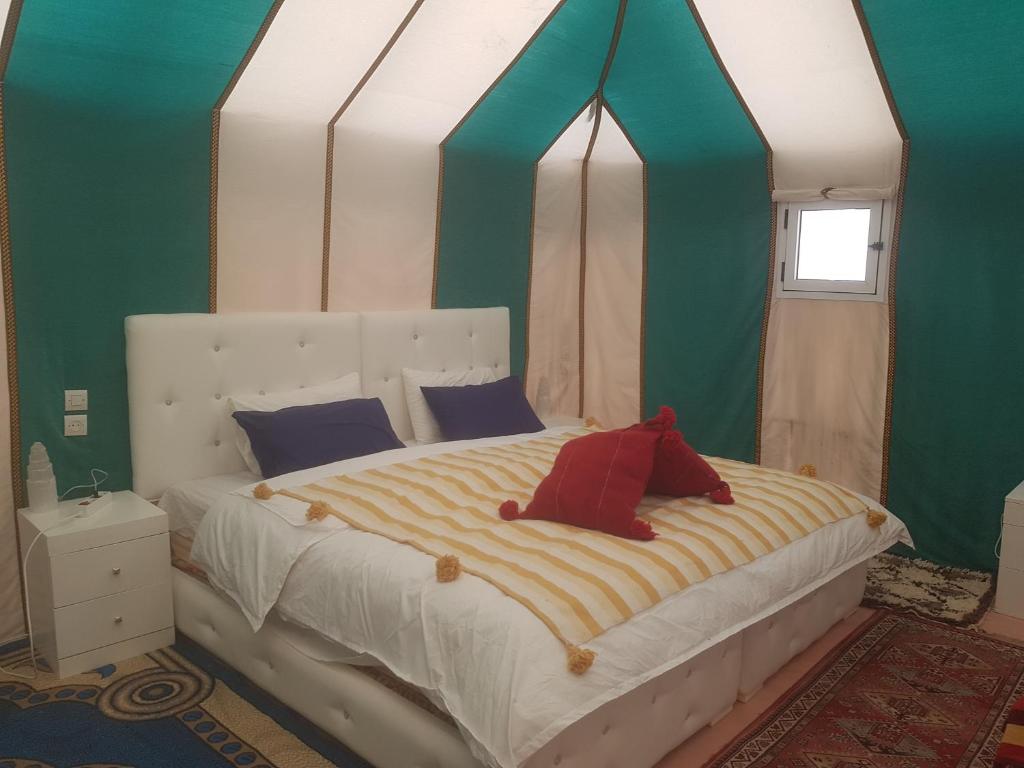 A bed or beds in a room at Merzouga Activities Camp