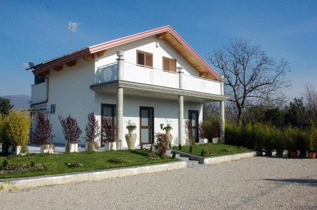 a white house with a balcony on top of it at B&B Desea in Poggiomarino