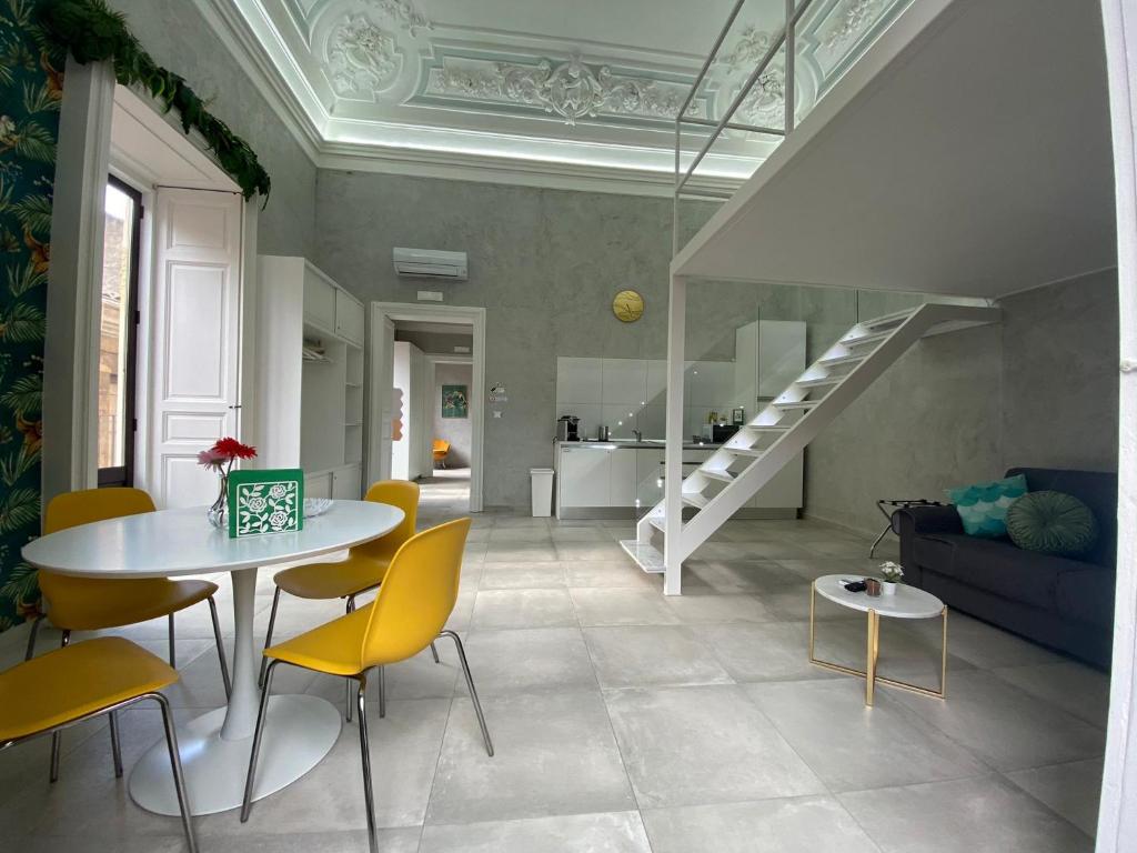 salon ze stołem i żółtymi krzesłami w obiekcie Superior Apartment Catania w Katanii