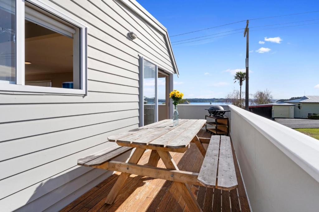 una mesa de picnic de madera en el balcón de una casa en Sea La Vie - Russell Holiday Home, en Russell