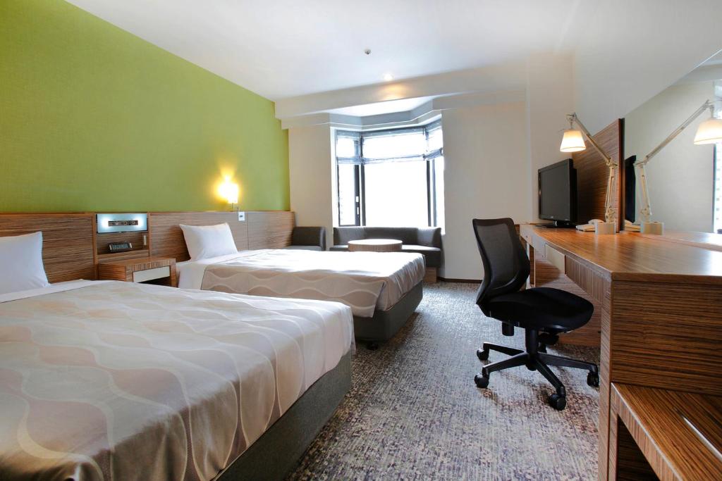 Habitación de hotel con 2 camas y escritorio en CYPRESS HOTEL Nagoya-eki Mae, en Nagoya