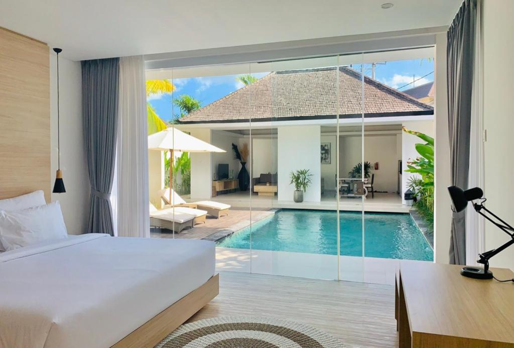 a bedroom with a bed and a swimming pool at Alami Luxury Villa in Seminyak