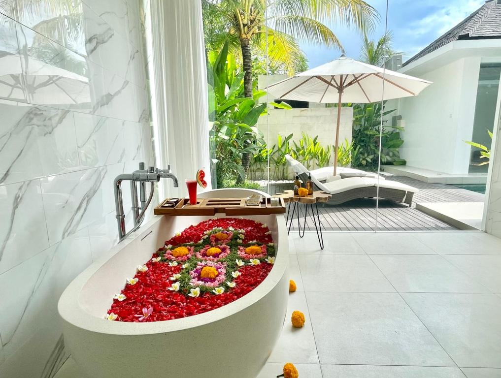 a bath tub filled with flowers in a bathroom at Alami Luxury Villa in Seminyak