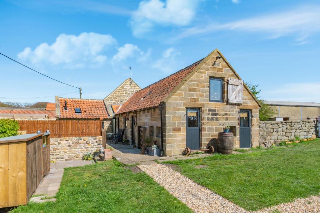 an old stone house with a stone wall at Basil's Barn in Whitby