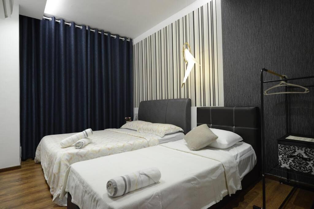 two beds in a room with blue curtains at 8pax Cozy Home Stay Jazz Suites 1 Vivacity Kuching Sarawak 3BR in Kuching