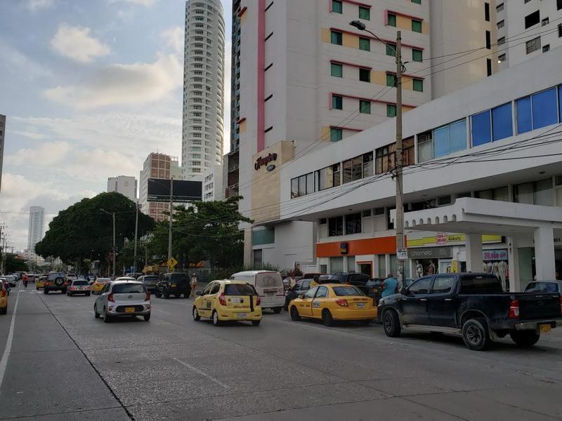 une rue urbaine animée remplie de voitures et de bâtiments dans l'établissement Apartamento amoblado en Bocagrande - Cartagena de Indias, à Carthagène des Indes