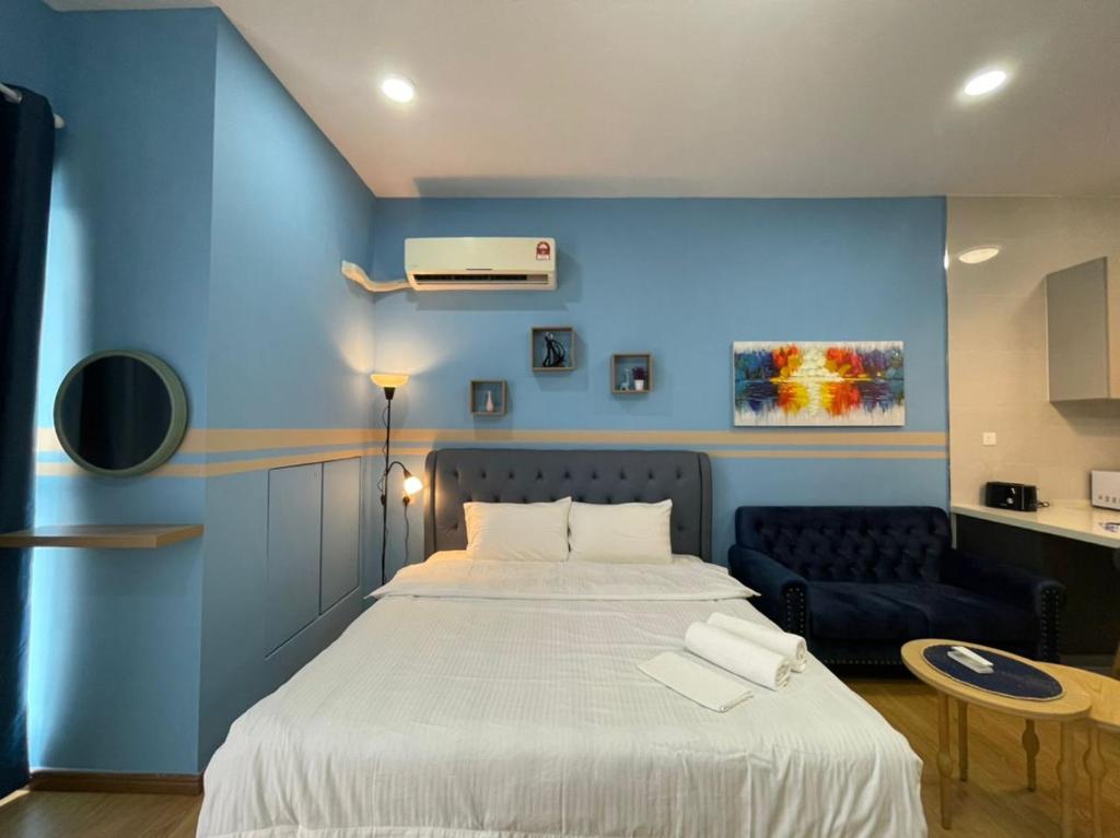 a blue bedroom with a bed and a blue wall at COUNTRY GARDEN@J Agape Homestay STUDIO 3C in Johor Bahru