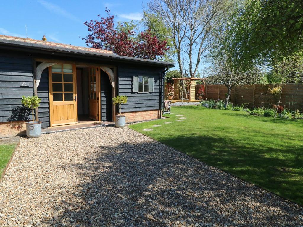 a house with a gravel driveway next to a yard at The Forge in Stowmarket