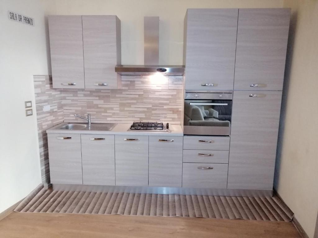 a kitchen with white cabinets and a sink at Nuovo Borgo - posizione ideale per visitare l'Umbria, Perugia, Assisi e le altre località in Deruta