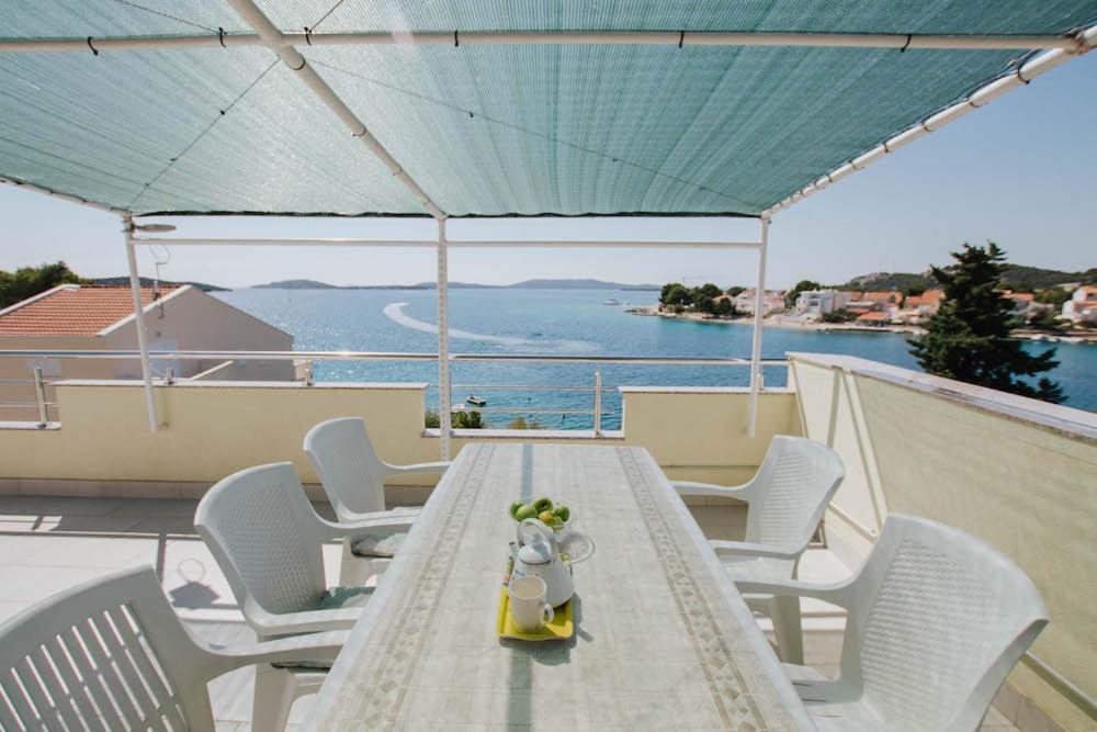 a table and chairs with a view of the water at Apartman Relax 2 in Zaboric