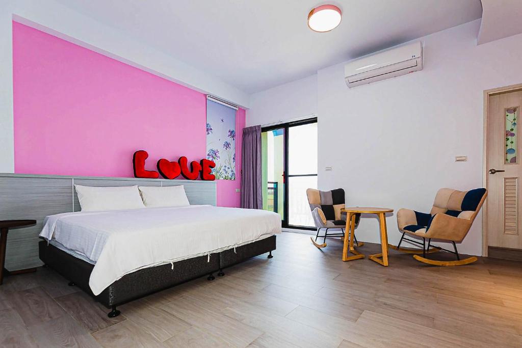Un dormitorio con una cama grande y una pared rosa en 澎湖金宿喜民宿Penghu Comfy B&B en Magong