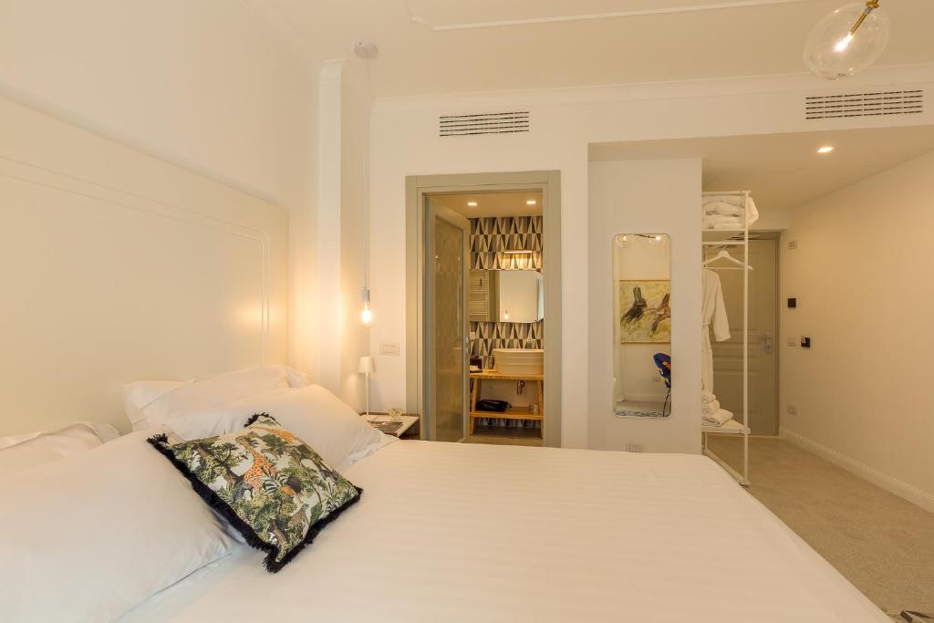 a bedroom with a white bed with a pillow on it at CasAunoE Boutique Hotel in Olbia