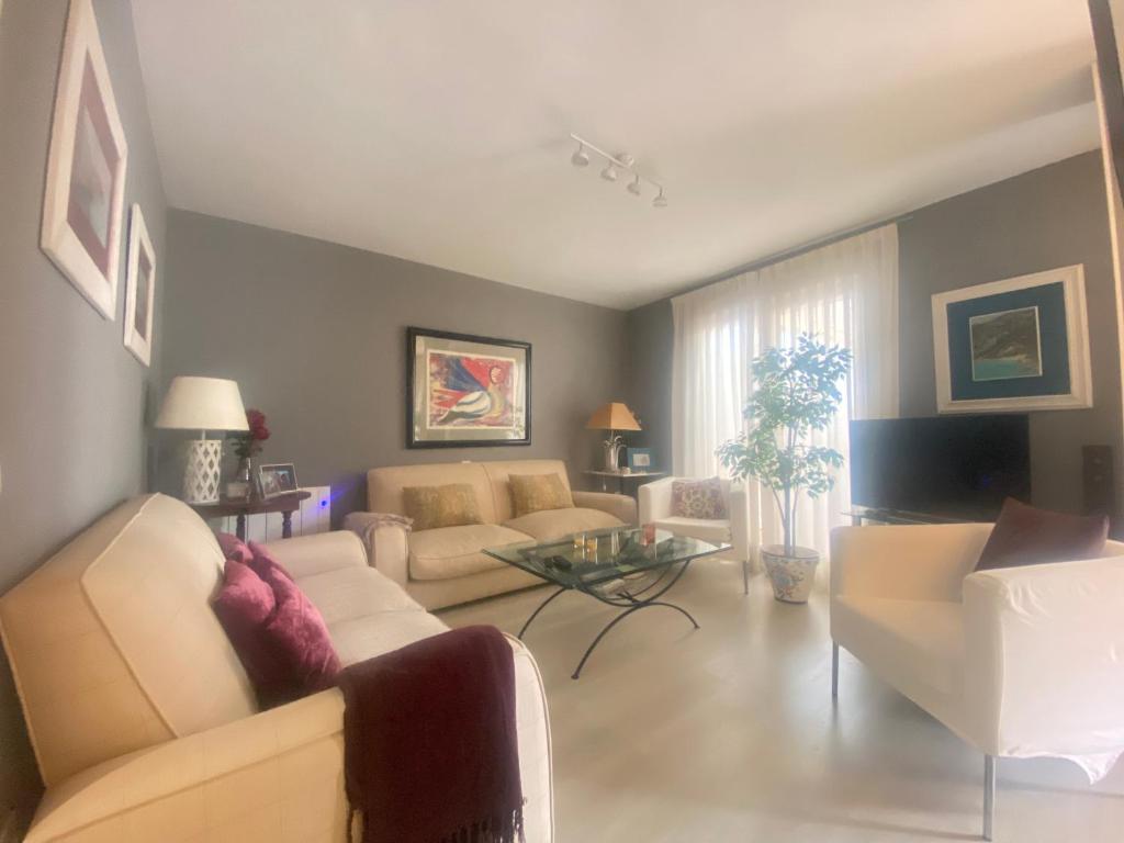 un salon avec un canapé et une table dans l'établissement Ático en Javea pueblo “Patraix”, à Jávea