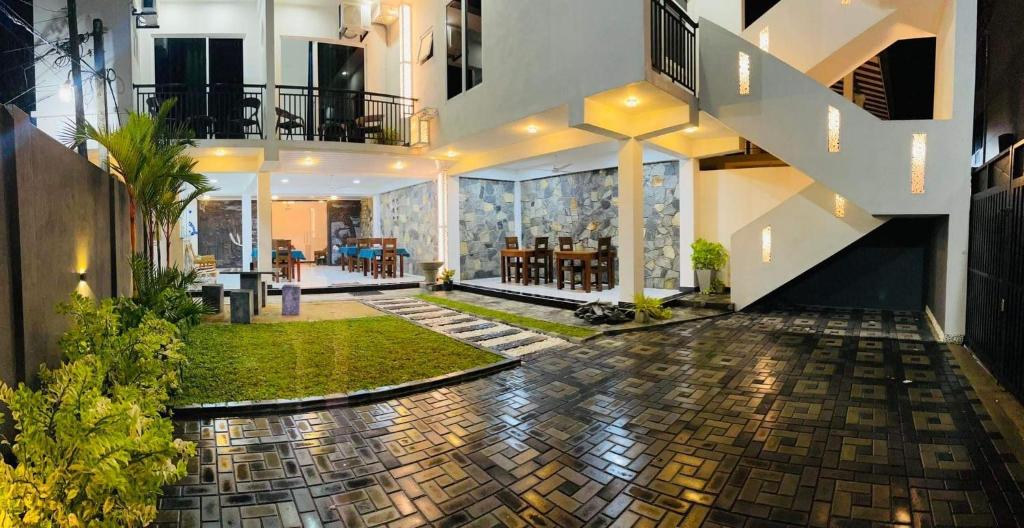 uma grande casa com um pátio com uma sala de estar em Funwhales Rest House em Negombo
