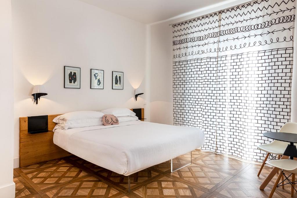 a bedroom with a white bed and a brick wall at Sleep B&B in Follonica