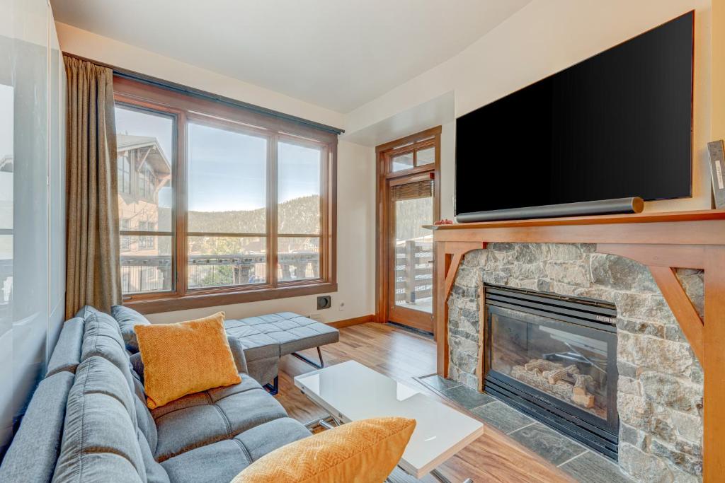 a living room with a fireplace and a flat screen tv at Snow Star Sanctuary in Olympic Valley