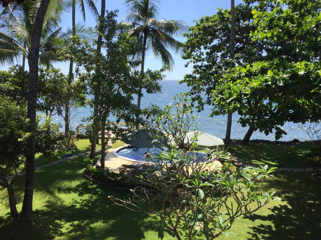 a view of the ocean from the garden of a resort at Bali Cottage Sambirenteng in Pabean Buleleng