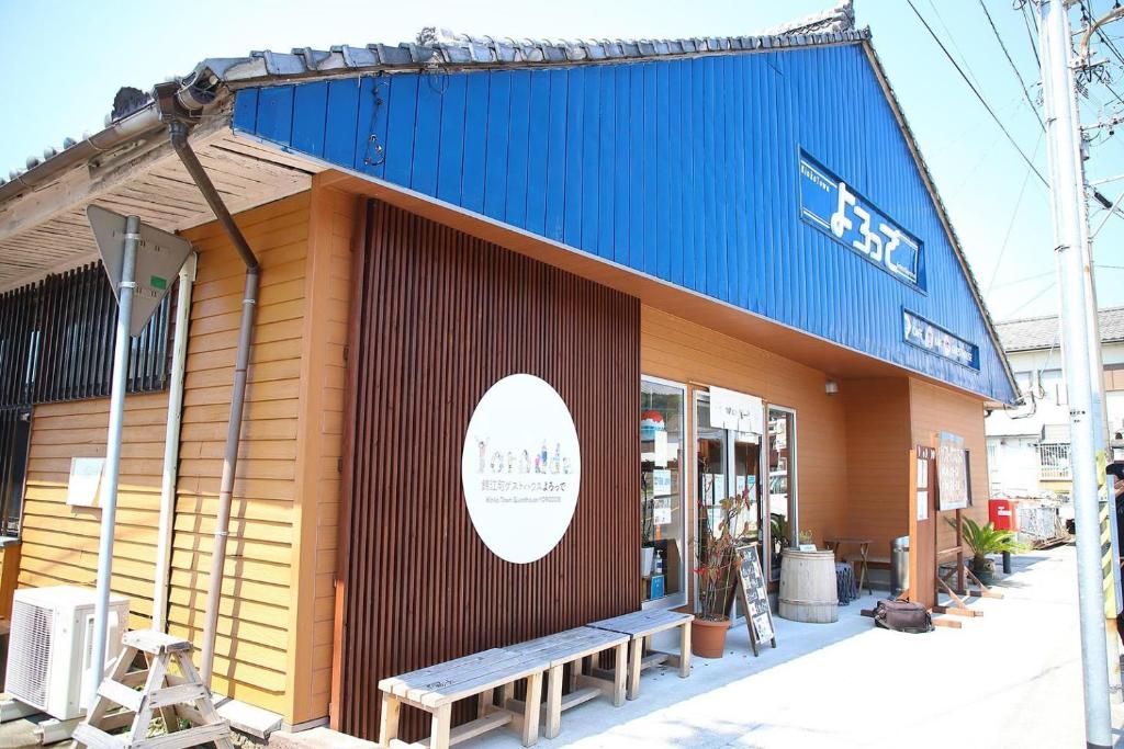 Kinkoにある錦江町ゲストハウス よろっでの前にベンチを持つ店舗
