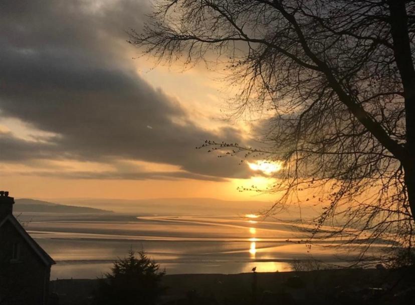 einen Sonnenuntergang über einem Wasserkörper mit Sonnenuntergang in der Unterkunft SANDYVIEWS in Grange Over Sands