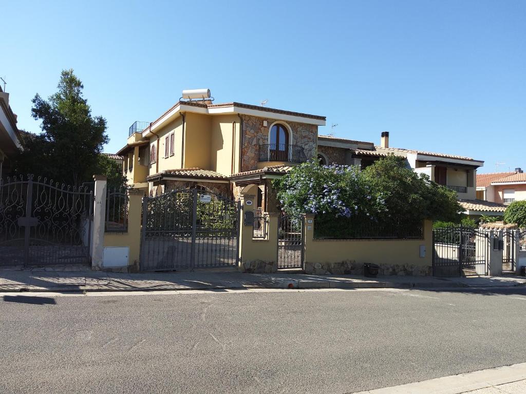a yellow house with a wrought iron fence at B&B Brezza di Mare (Sea Breeze) in Villasimius
