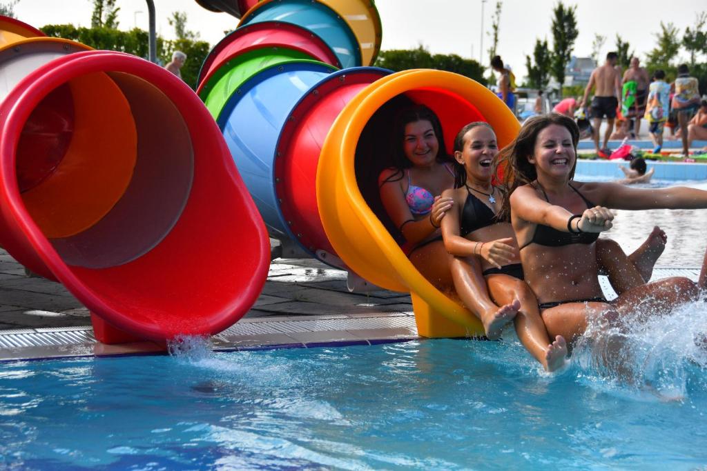 Hotel Villa Robinia في كاسال بورسيتي: ثلاث بنات في الماء عند المسبح
