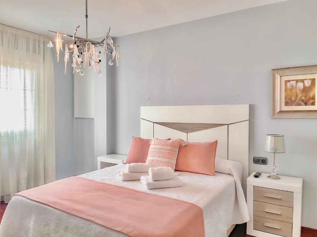 um quarto com uma cama grande e almofadas cor-de-rosa em Pension As Burgas Ii em Caldas de Reis