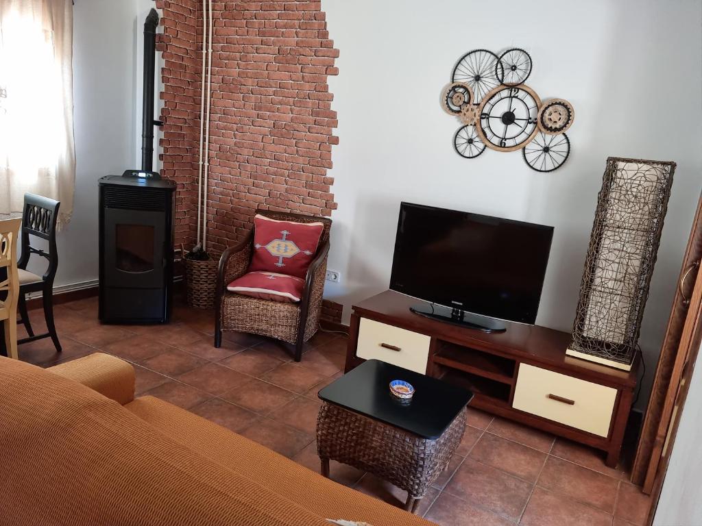 een woonkamer met een bank en een flatscreen-tv bij Casa Mari in Palomera