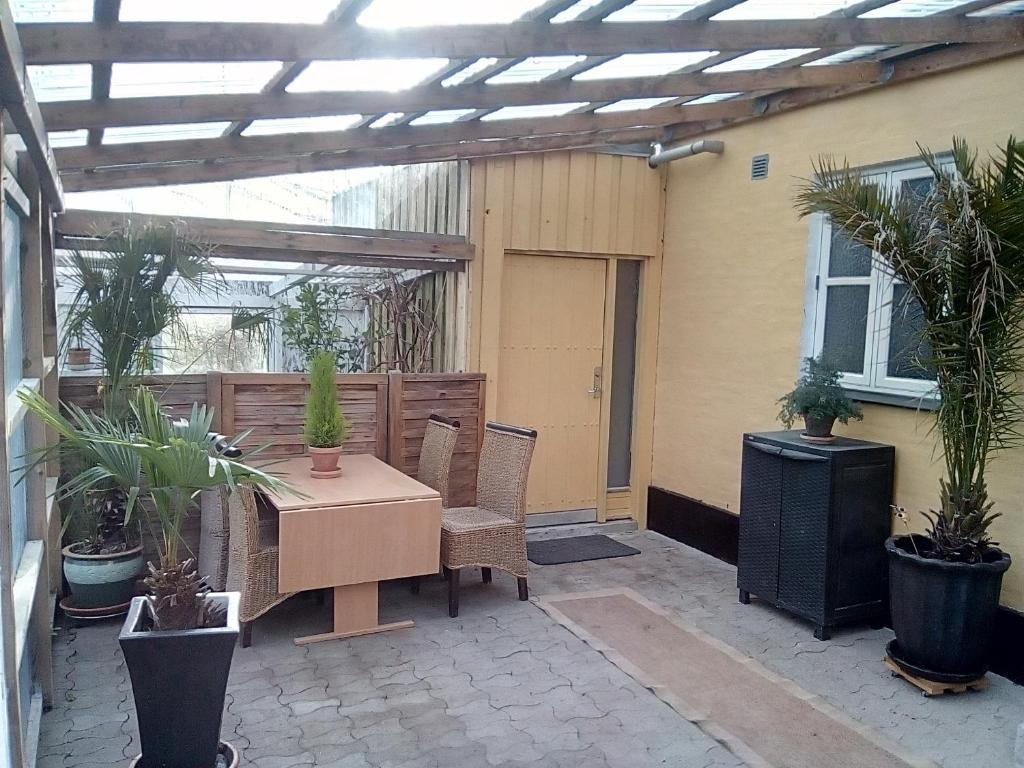 eine Terrasse mit einem Tisch, Stühlen und Pflanzen in der Unterkunft Idyllic country house in Vadum