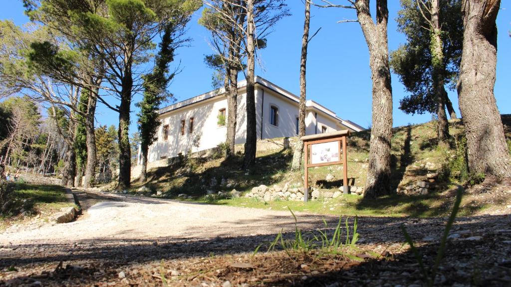 uma casa velha no lado de uma colina com árvores em Ostello Ossigeno em Campodimele