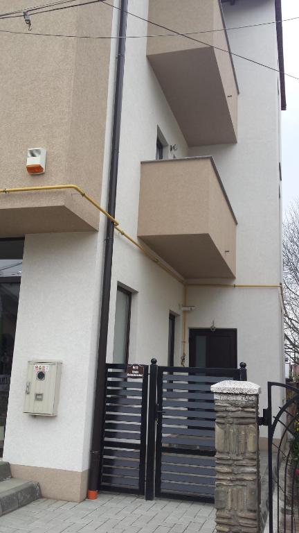 un bâtiment avec une porte noire devant lui dans l'établissement Apartament Mario, à Rădăuţi