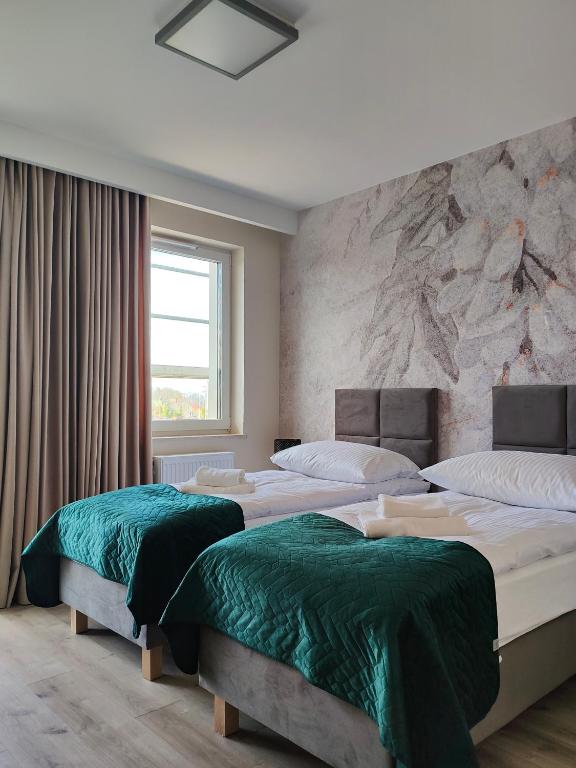 a bedroom with three beds with green sheets at Hullo in Lubawa
