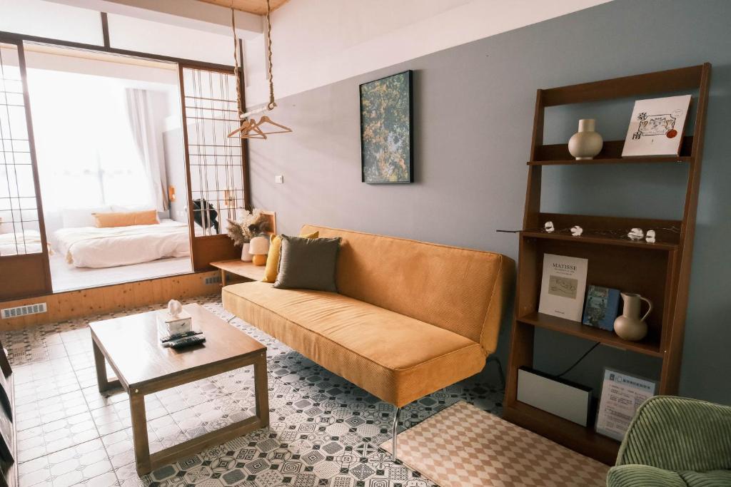 uma sala de estar com um sofá e uma mesa em South Gate Home Stay em Tainan