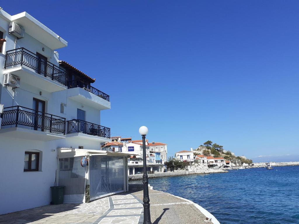 um edifício branco ao lado de uma massa de água em Maria's room em Samos