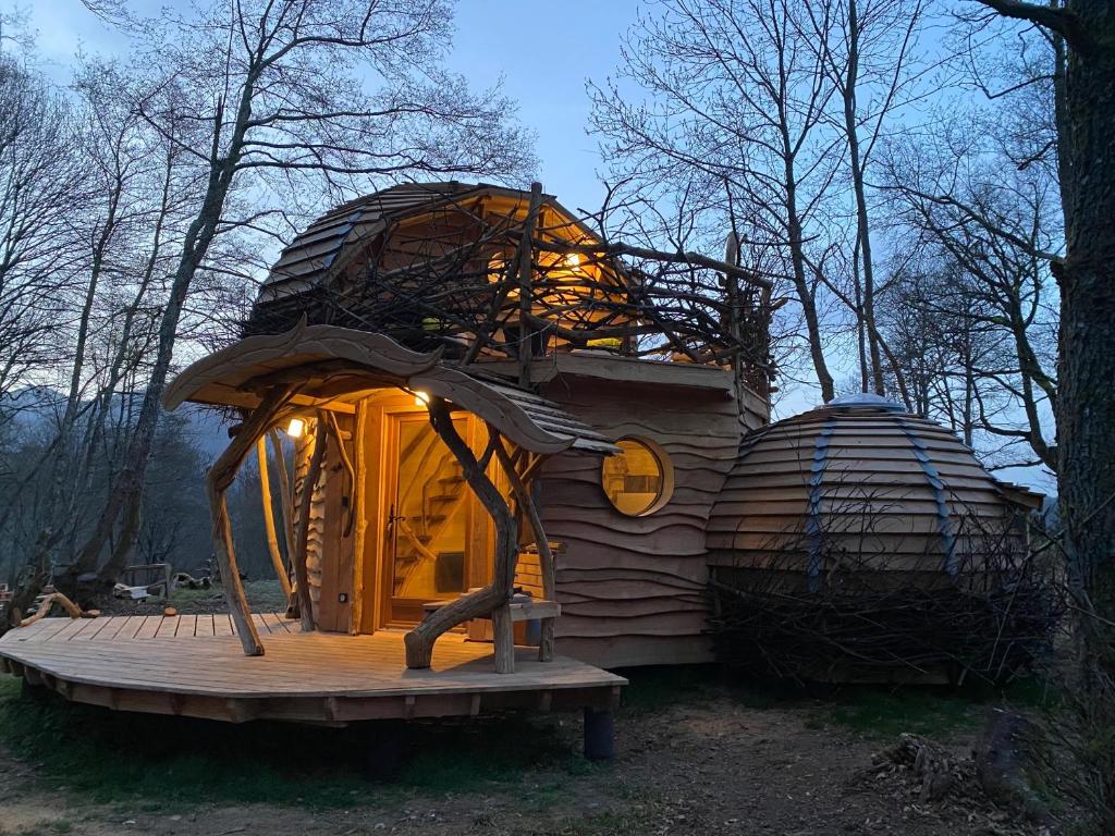 een houten hut met een boomhut in het bos bij Les Cabanes De Pyrene in Cazarilh