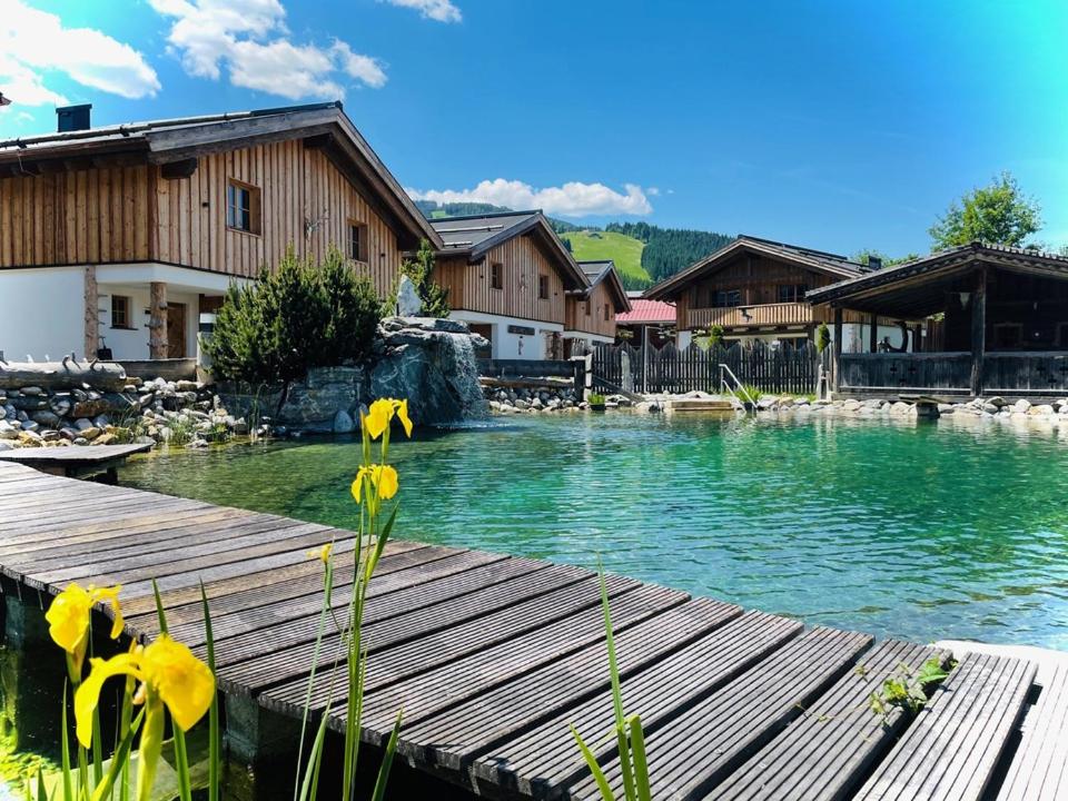 a pool of water with yellow flowers on a wooden deck at Sieglhub Chalets - Appartements - Hotel in Flachau