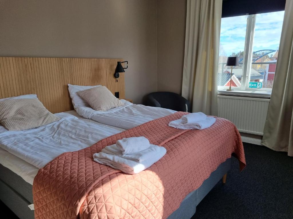 um quarto de hotel com duas camas com toalhas em Byske Gästgivargård em Byske