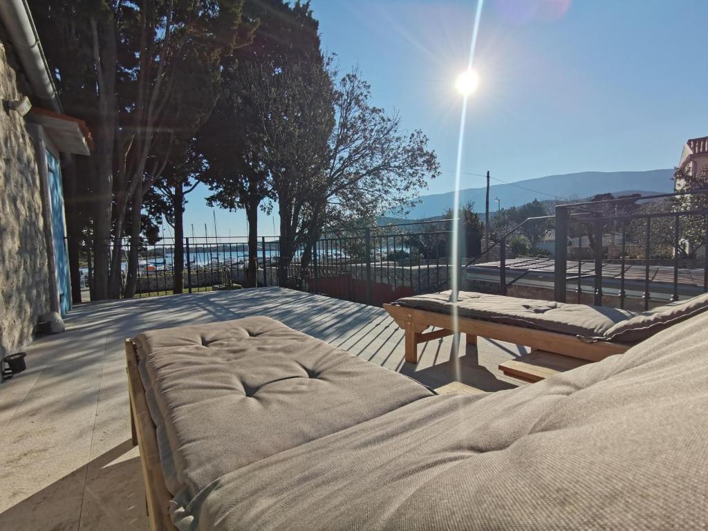 een bed en een picknicktafel op een patio bij VILA SIRENA OSOR in Mali Lošinj